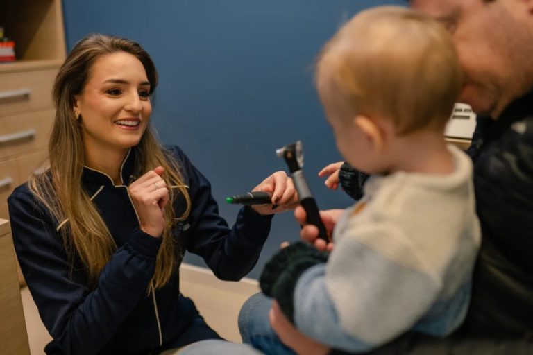 Especialista realizando avaliação auditiva infantil com criança na Clínica Amplific